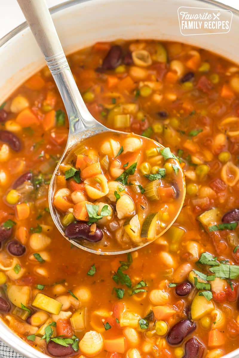 A ladleful of Minestrone soup from a pot