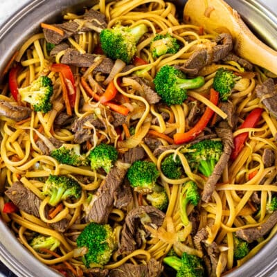 Skillet of Steak Stir Fry with a wooden spoon.