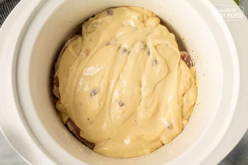 Pork chops in crock pot with soups poured on top for a creamy gravy.