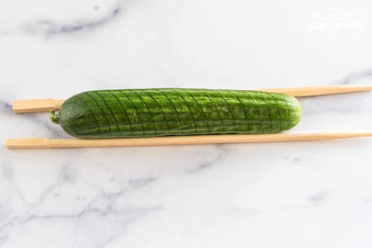 mini cucumber between two chopsticks cut in angled slices