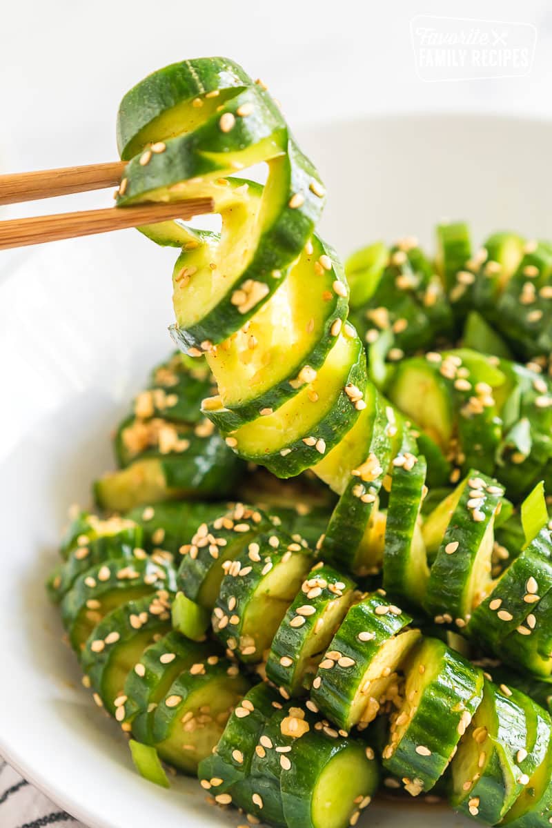 Chopsticks pulling up a bite of spicy cucumber salad