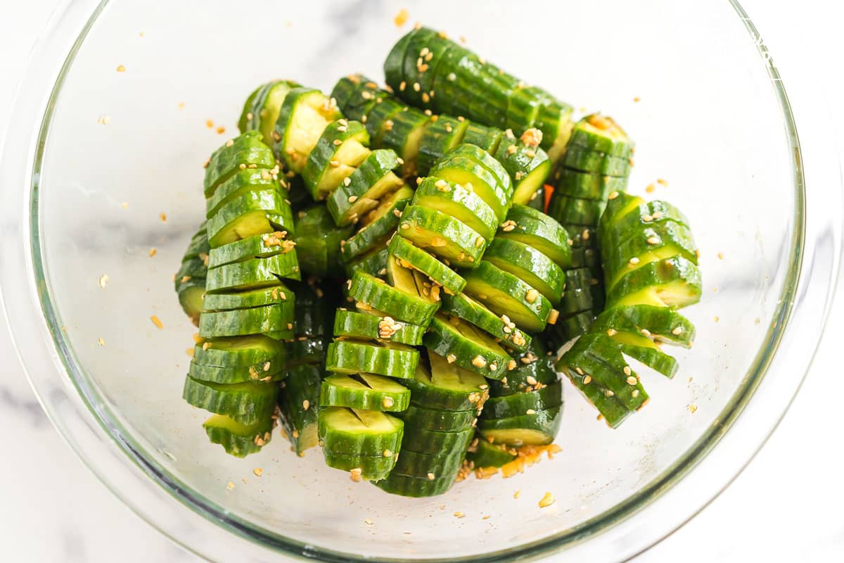 spiral cut cucumbers tossed in dressing in a bowl