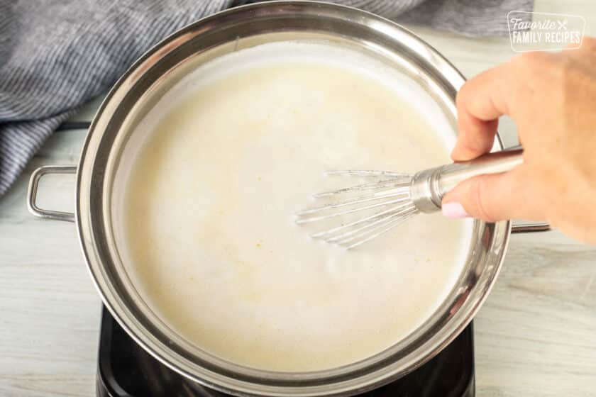 Whisking grits in boiling saucepan.