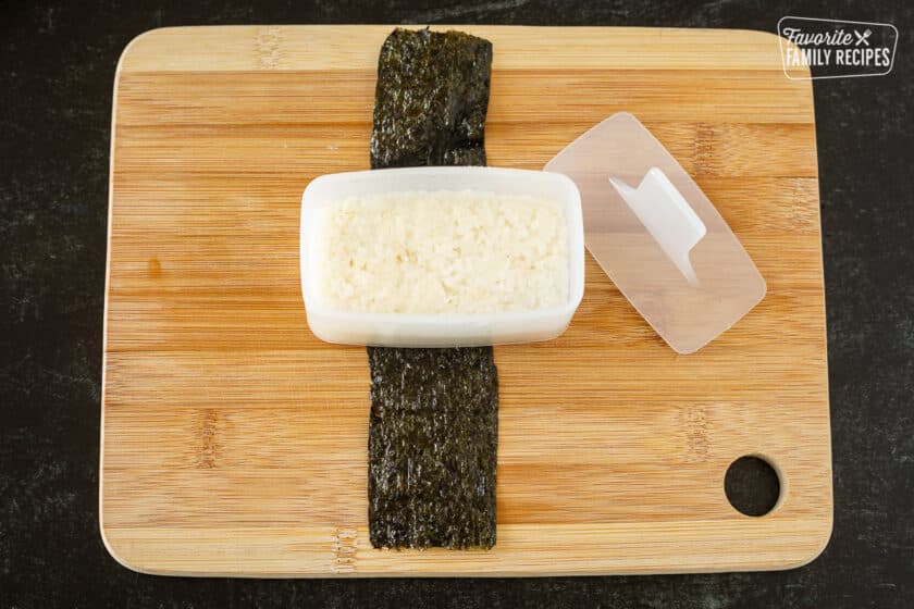 Pressed sushi rice in a Musubi mold demonstrating how to make Spam Musubi.