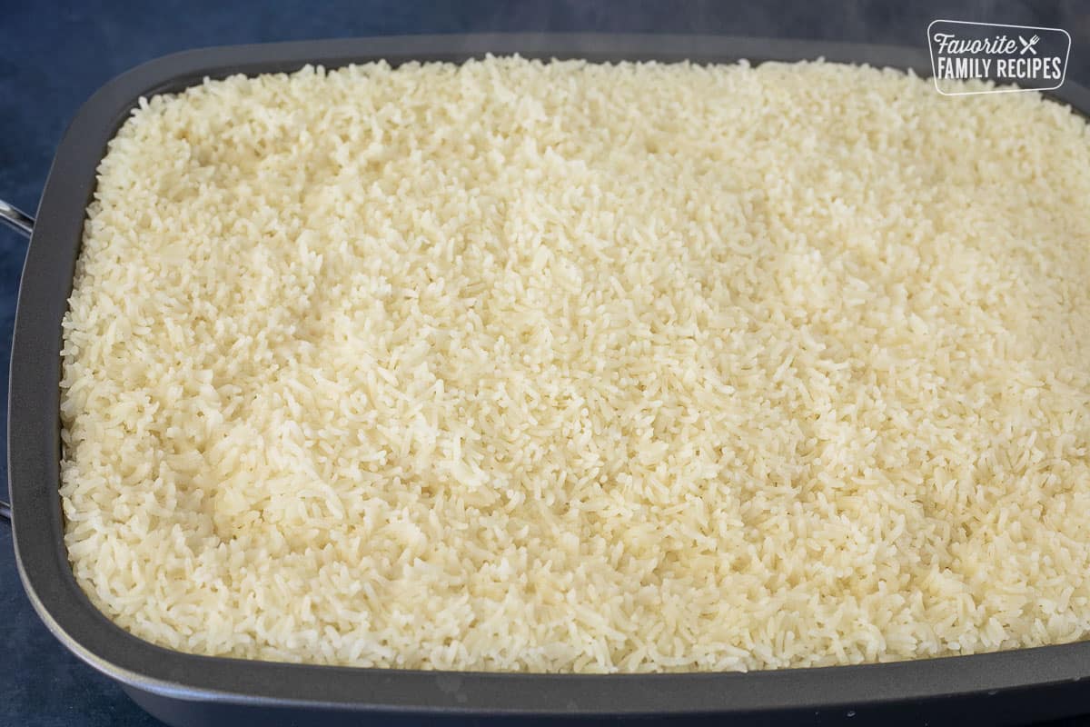 Cooked and steamy rice in a roasting pan.