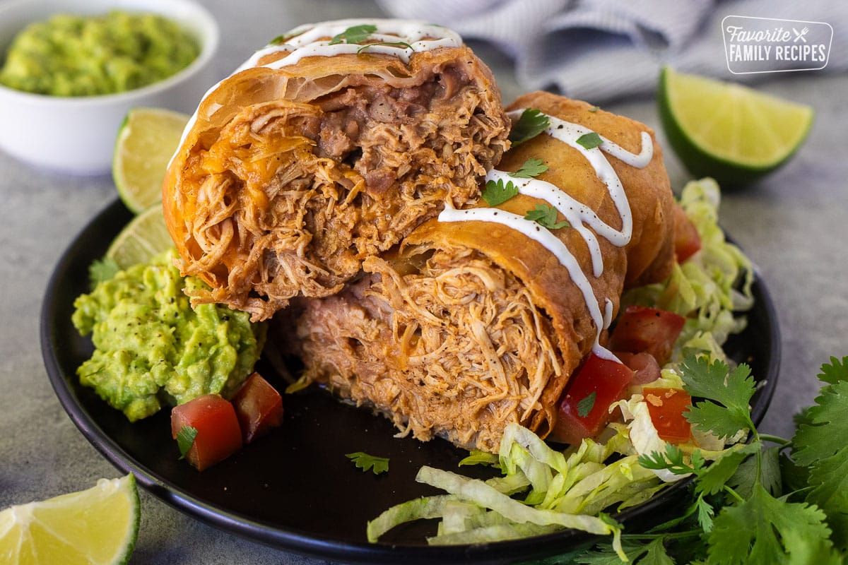 Cut in half Chicken Chimichanga with sour cream drizzled on top and cilantro.