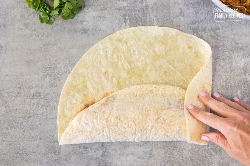 Folding a flour tortilla.