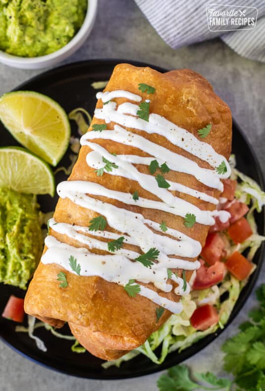 Chicken Chimichanga with sour cream drizzled on top and cilantro.