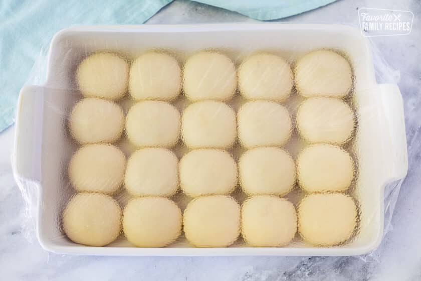 Rolls rising in a baking dish, a step to preparing a Pani Popo recipe.