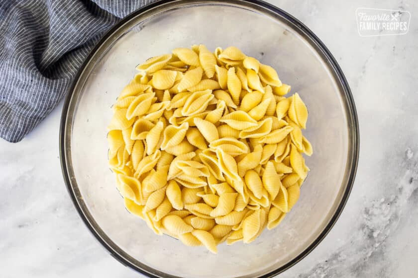 Glass bowl with cooked shell pasta.