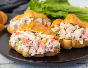 Three Crab Salad Sandwiches on a plate.