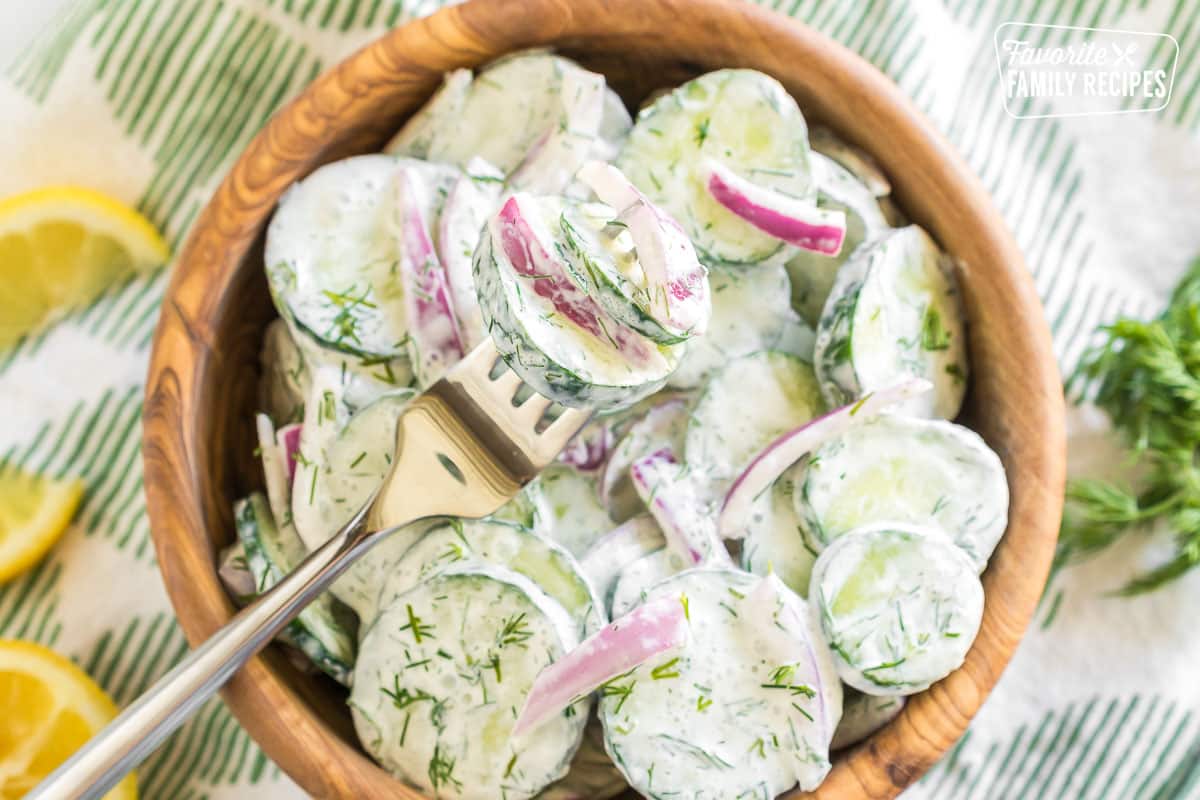 A forkful of cucumbers and onions with dill dressing