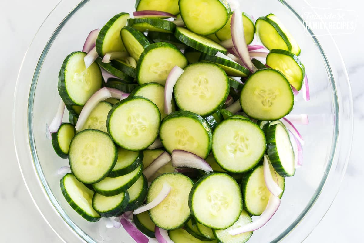 Sliced cucumbers and red onions in a bowl