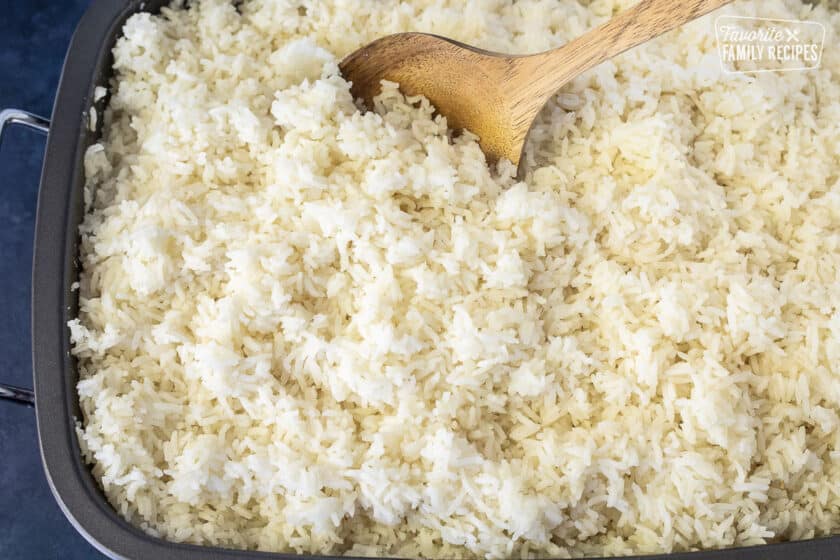 Fluffing up the rice from a roasting pan.