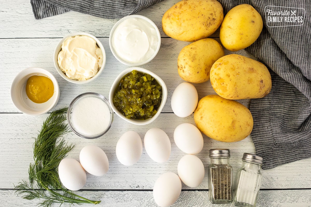 Ingredients to make Homemade Potato Salad including potatoes, sour cream, mayo, relish, salt, pepper, hard boiled eggs, sugar, mustard and dill.