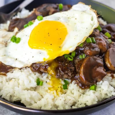 Close up of a bowl with Loco Moco topped with green onion.