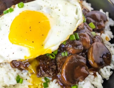 Loco Moco in a bowl with the yolk dripping down.