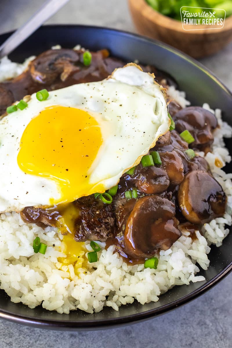 Loco Moco in a bowl with the yolk dripping down.