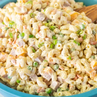 Large bowl of Macaroni Salad with wooden spoon.