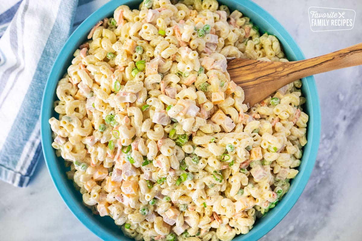Bowl of Macaroni Salad with a wooden spoon.