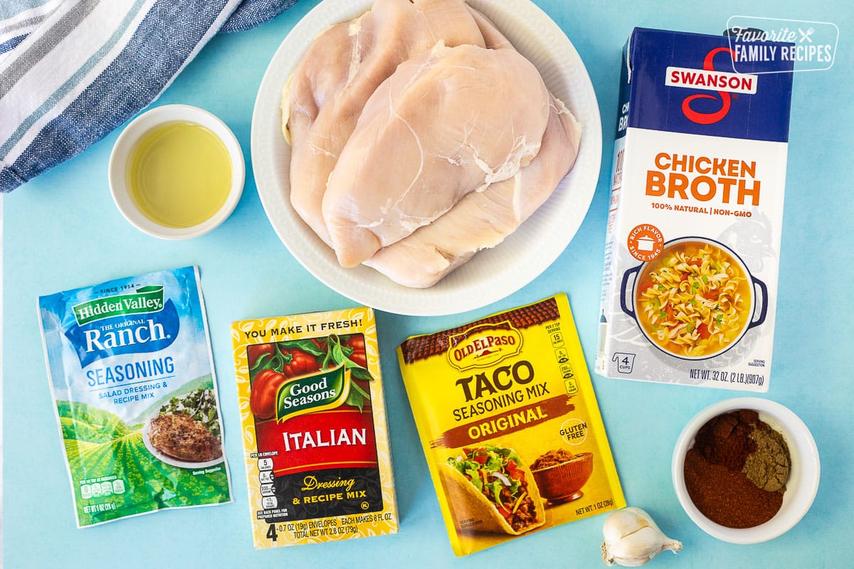 Ingredients to make Mexican Shredded Chicken including chicken breasts, chicken broth, oil, ranch seasoning mix, Italian dressing recipe mix, taco seasoning, garlic and additional seasonings.