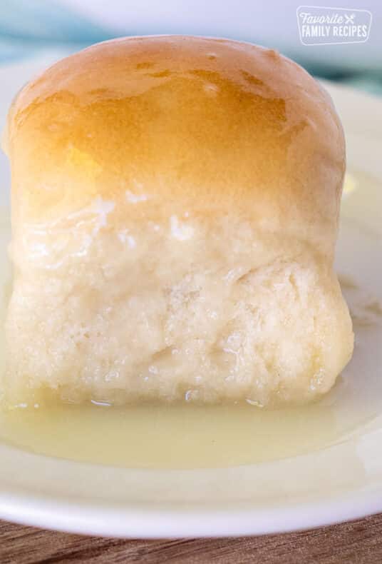 Close up of a Pani Popo Samoan Coconut roll on a plate with coconut sauce.