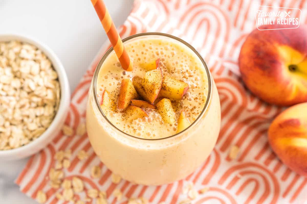 Smoothie topped with cut peaches and cinnamon