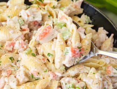 Spoon scooping Crab Pasta Salad out of a bowl.