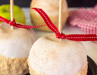 Two Apple Pie Caramel Apples on a plate.