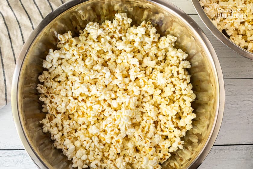 Two bowls of popped popcorn with butter and salt.