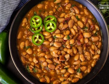 Bowl of Charro Beans garnished with sliced jalapeños.