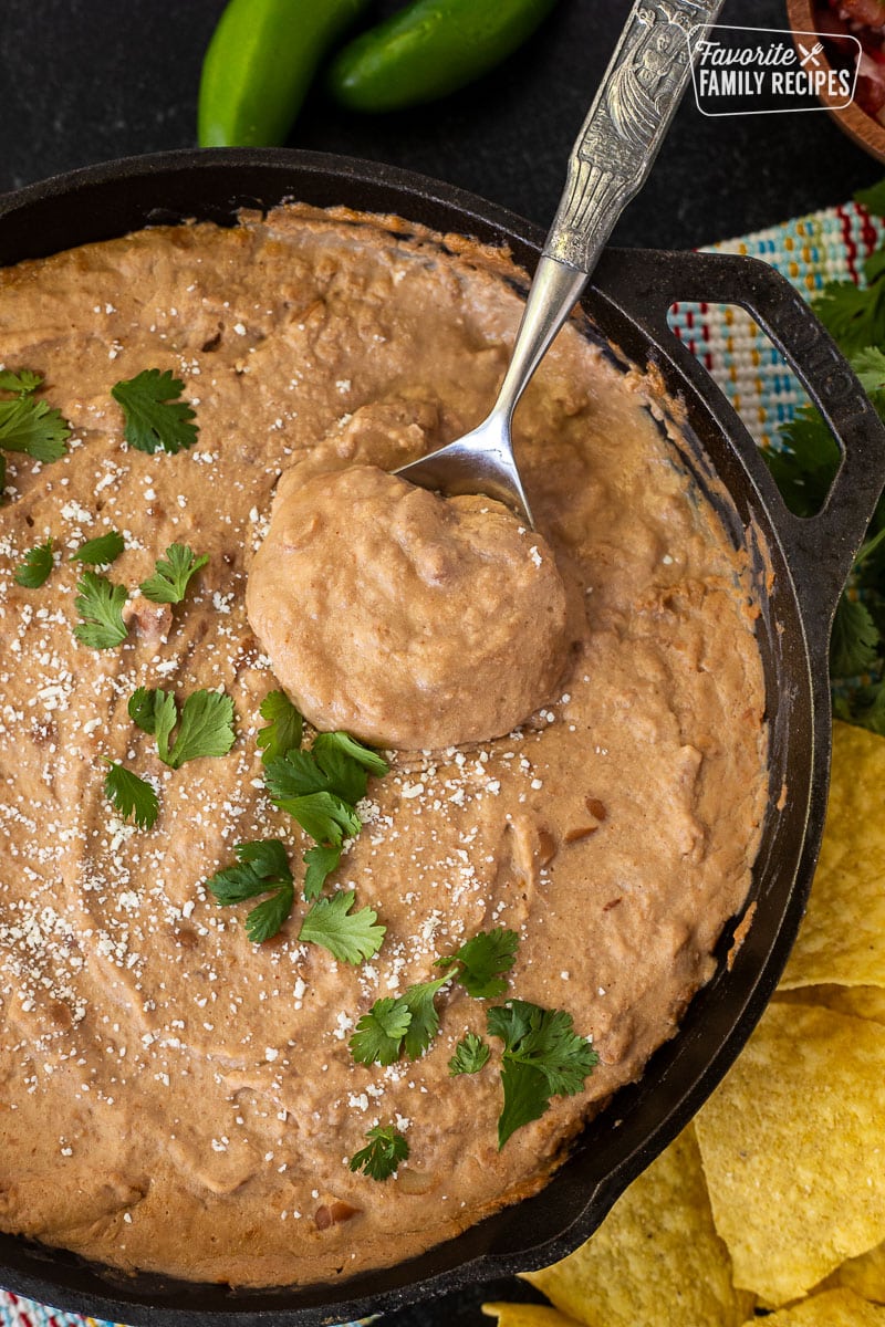 Spoon with Cheater Refried Beans in a skillet.