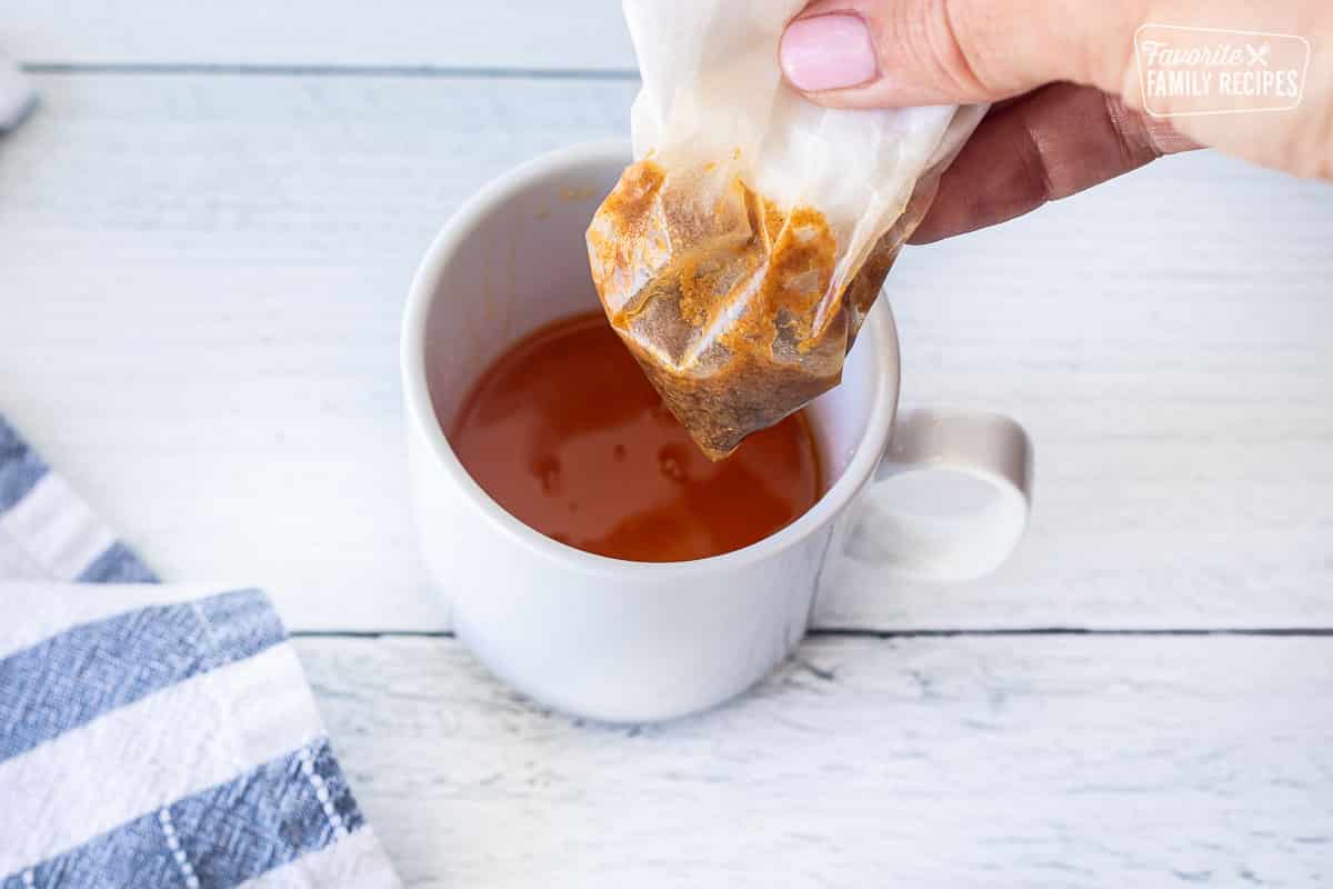 Holding a coffee filter over a cup of clarified butter.