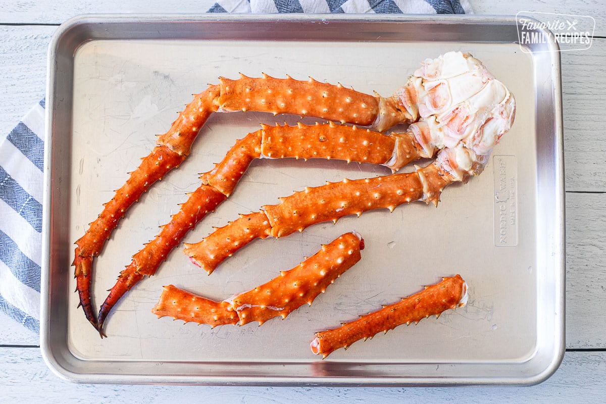 Sheet pan with pieces of king crab legs.