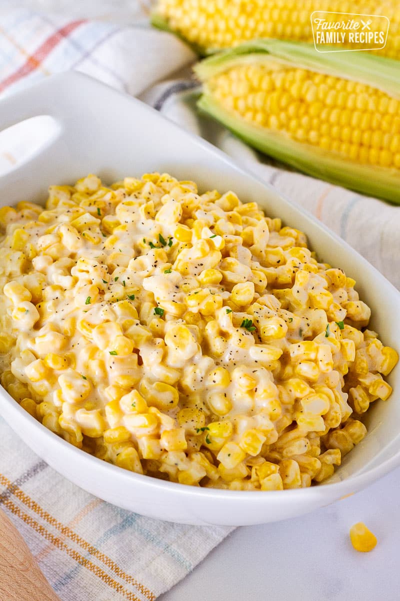 Bowl of Creamed Corn. Fresh corn in the background.