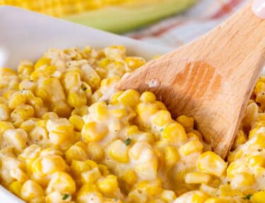 Spoon stirring bowl of Creamed Corn.