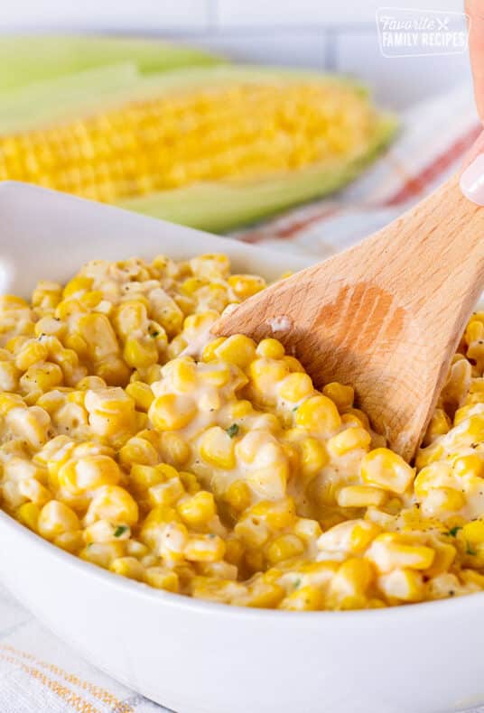 Spoon stirring bowl of Creamed Corn.