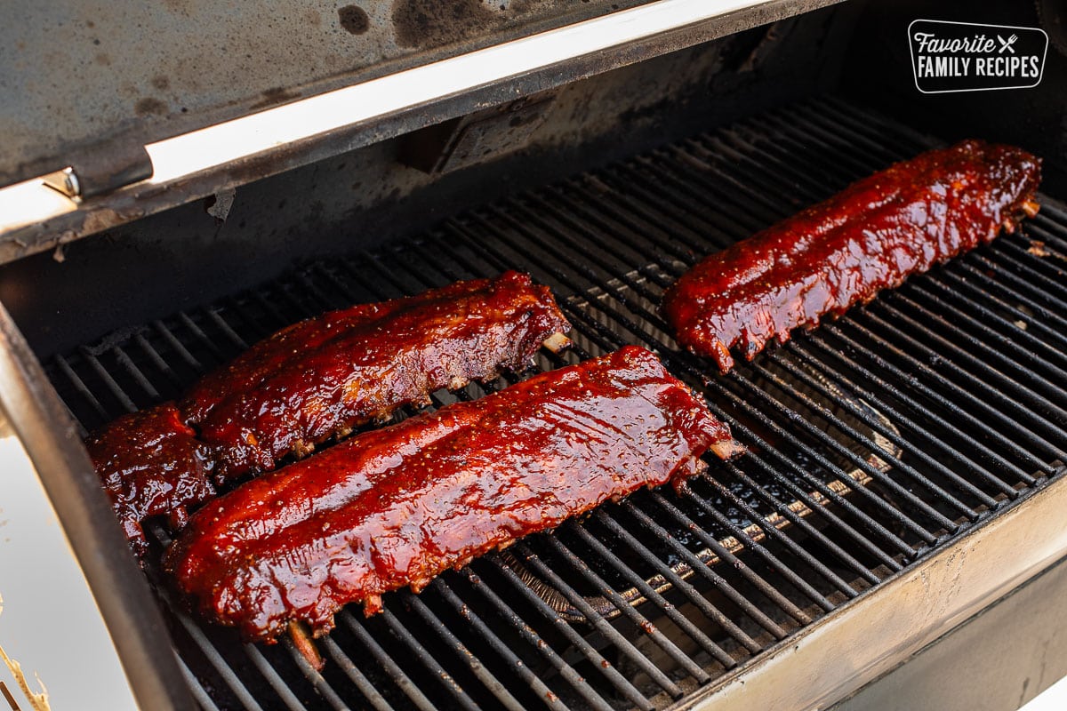 Three racks of glazed Smoked Ribs on a smoker.