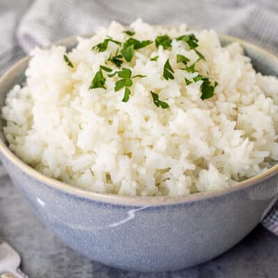 Bowl of Long Grain Rice topped with parsley for garnish.