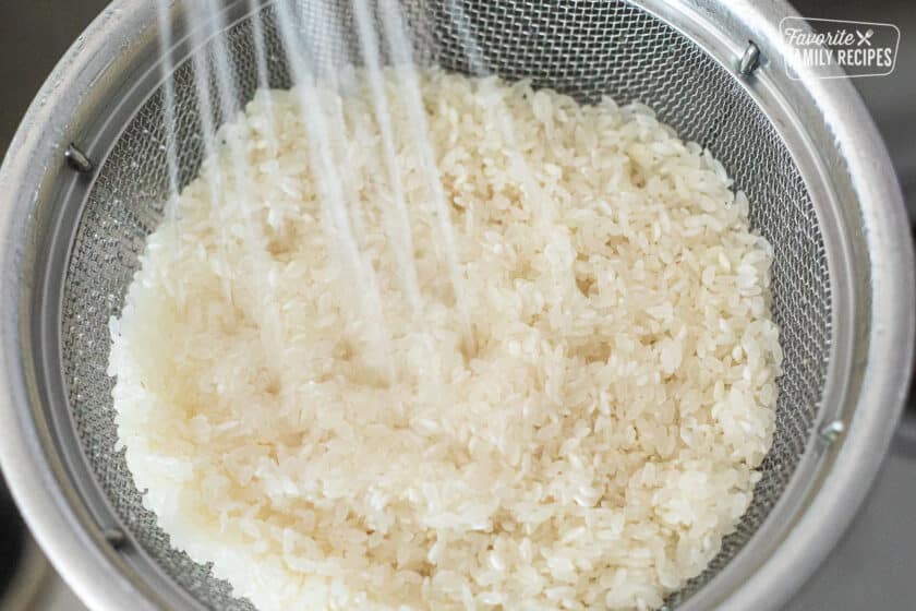 Rinsing rice in a colander.