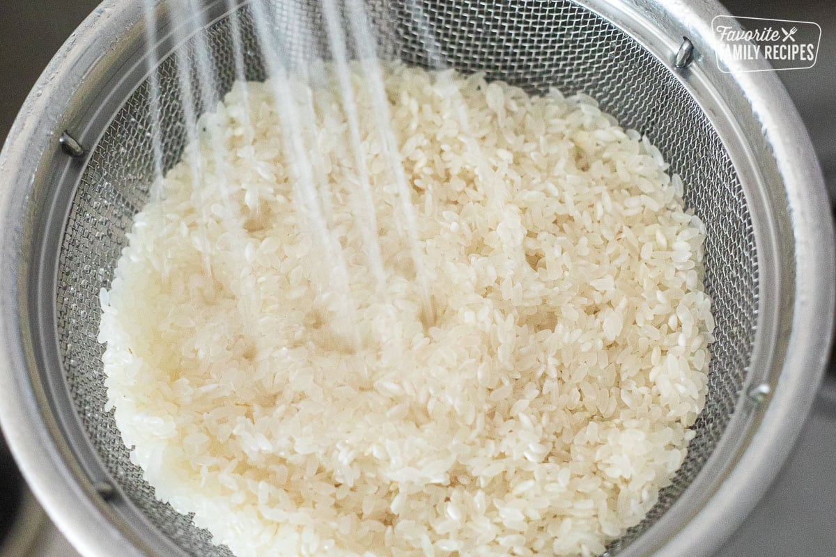 Rinsing rice in a colander.