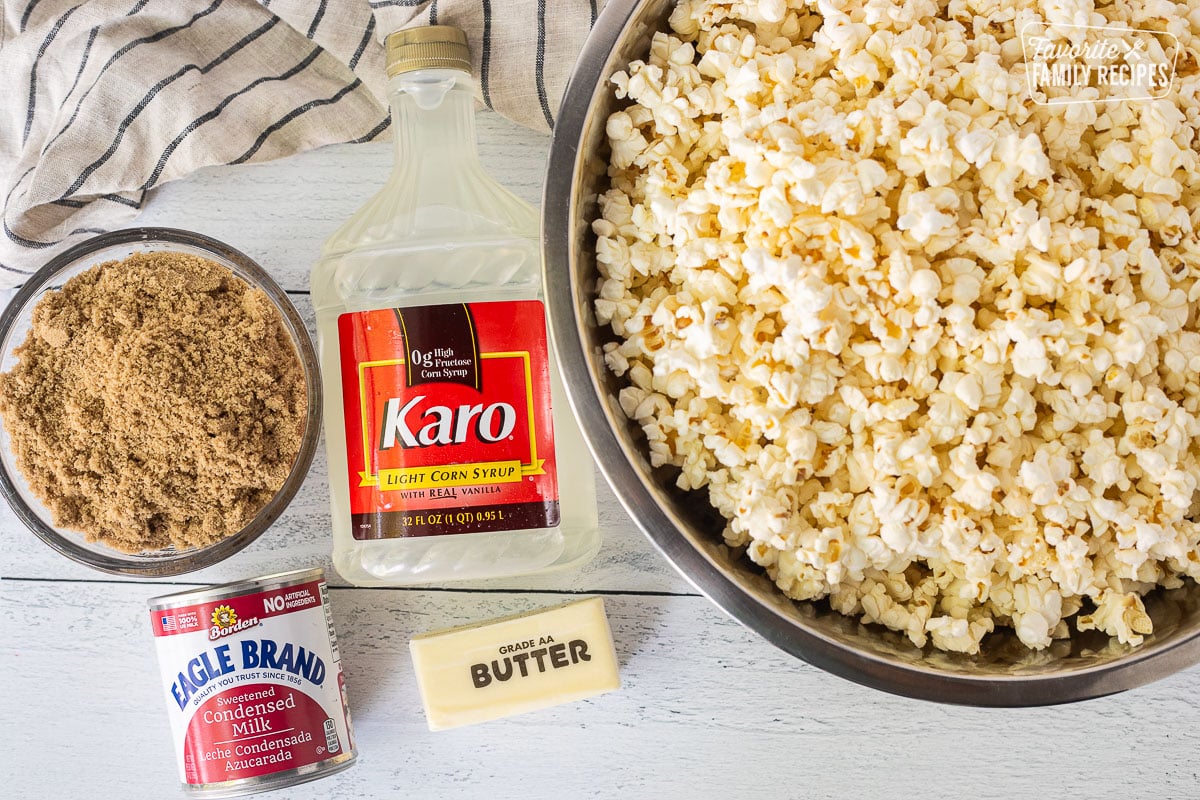 Ingredients to make caramel popcorn including butter and salted popcorn, brown sugar, corn syrup, butter and sweetened condensed milk.