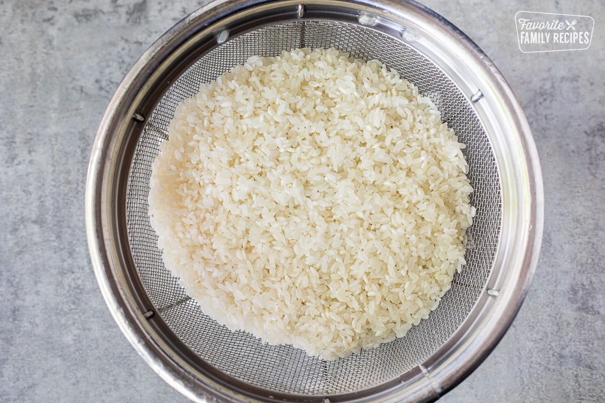 Rinsed rice draining in a colander.