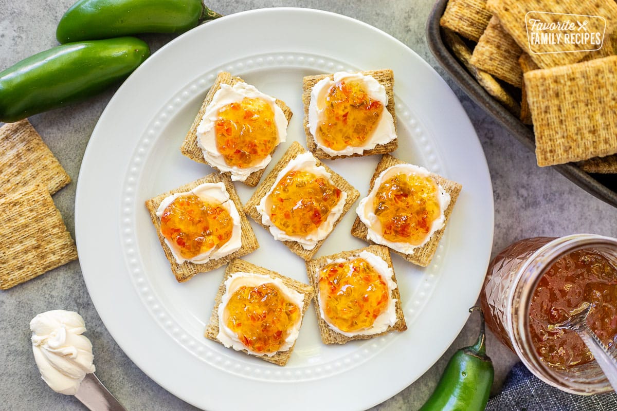 Plate with crackers spread with cream cheese and jalapeño pepper jelly.