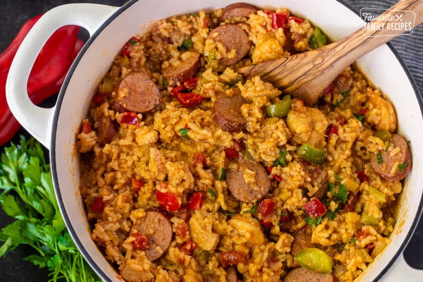 Jambalaya in a dutch oven and wooden spoon.