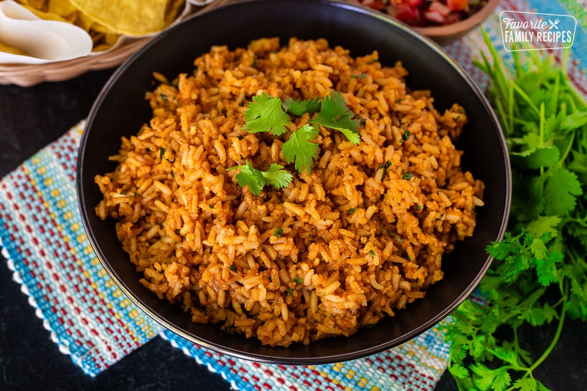 Cooked Mexican Rice side dish in a bowl topped with a sprig of cilantro.