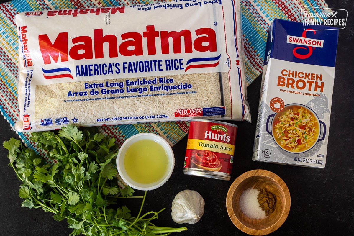 Ingredients to make Mexican Rice including long grain rice, chicken broth, tomato sauce, seasonings, garlic, olive oil and cilantro.