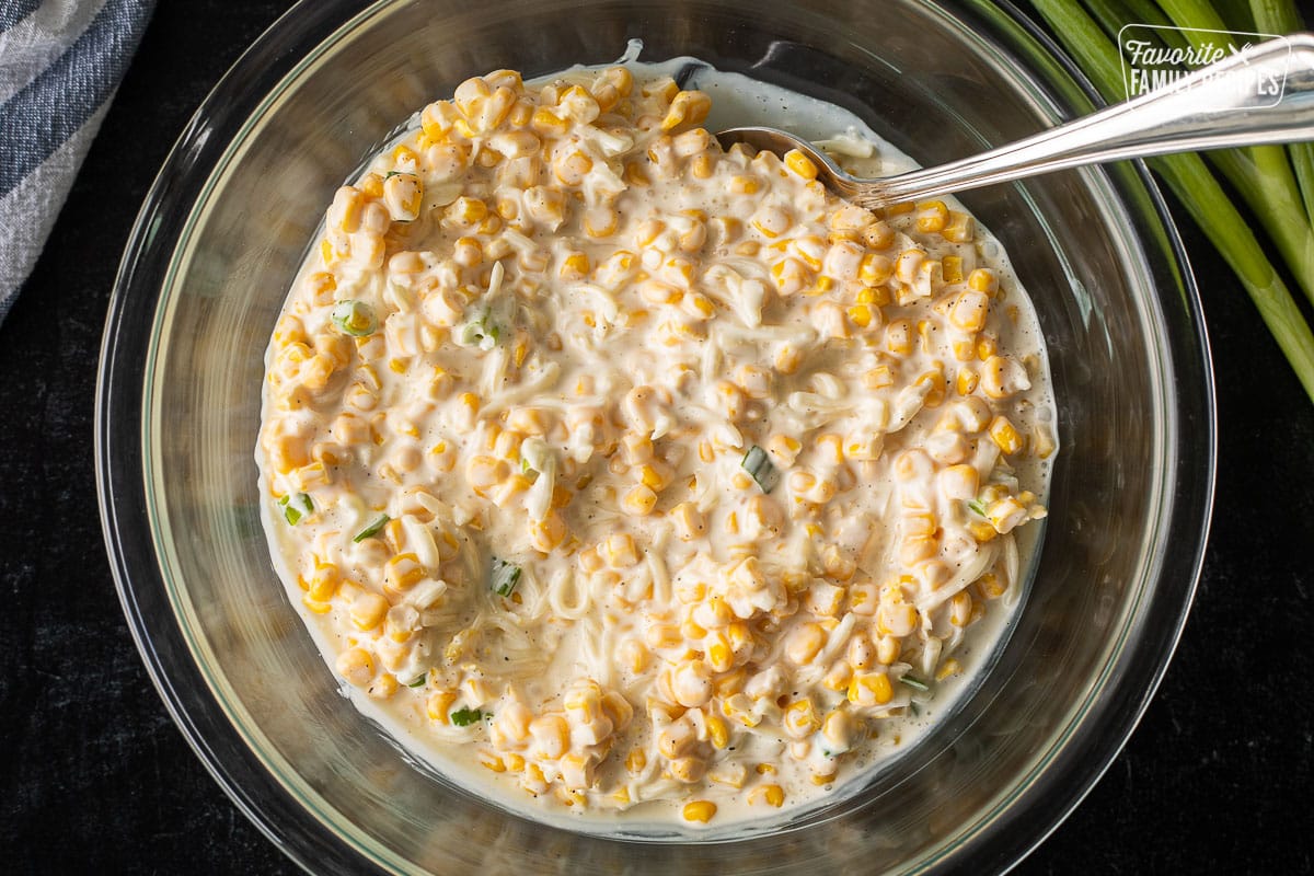 Mixing Corn Cheese ingredients in a bowl with a spoon.