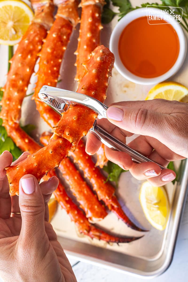 Cracking open a piece of crab legs with a cracking tool.