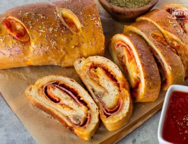 Slices of Stromboli next to pizza sauce.